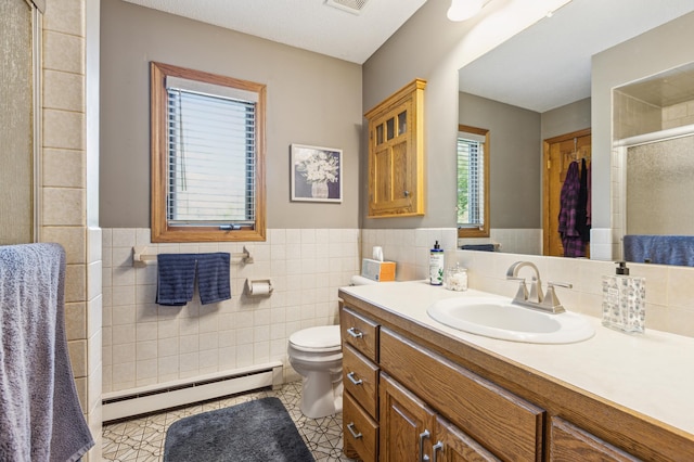 5651 164th Ln NW, Ramsey, MN 55303 - full bathroom featuring baseboard heating, tile walls, a stall shower, vanity, and toilet