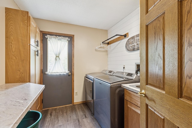 5651 164th Ln NW, Ramsey, MN 55303 - laundry room with washing machine and dryer, wood finished floors, cabinet space, and wood walls