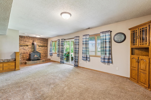 5651 164th Ln NW, Ramsey, MN 55303 - unfurnished living room with a wood stove, a textured ceiling, carpet floors, and baseboards