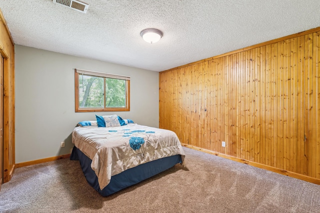 5651 164th Ln NW, Ramsey, MN 55303 - carpeted bedroom featuring wooden walls, baseboards, and a textured ceiling