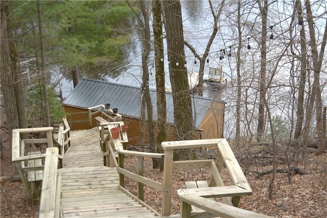 view of property exterior featuring metal roof and a water view