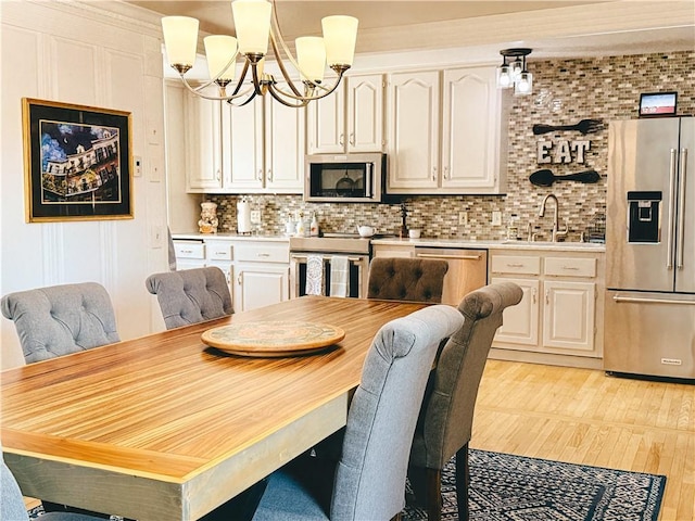 dining area with a chandelier and light wood-type flooring