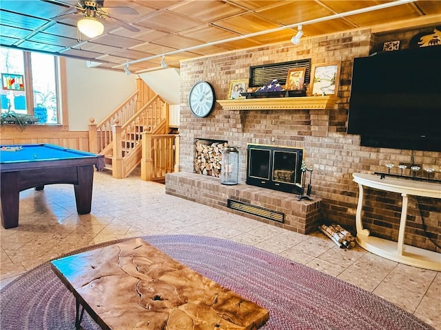 game room with a fireplace, rail lighting, wainscoting, a ceiling fan, and billiards