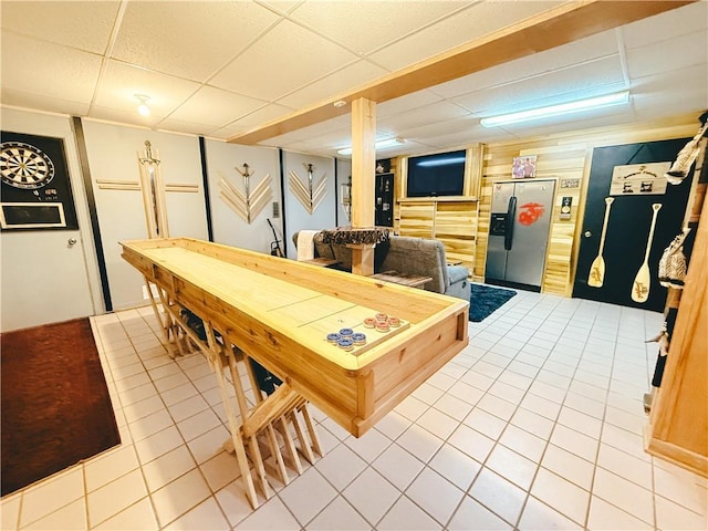game room with a drop ceiling and light tile patterned floors