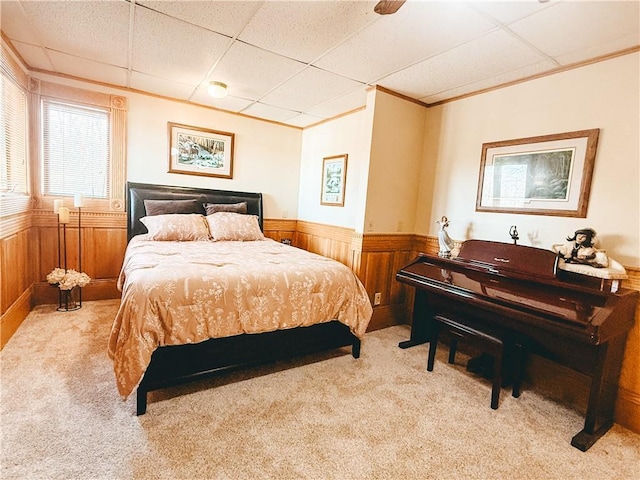 carpeted bedroom with a wainscoted wall, a paneled ceiling, and wood walls