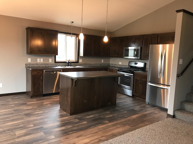 kitchen with appliances with stainless steel finishes, dark countertops, a sink, dark brown cabinetry, and dark wood-style floors