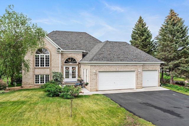 2001 Stonepine Ave, Hudson, WI 54016 - view of front of home featuring french doors, asphalt driveway, a front yard, an attached garage, and brick siding