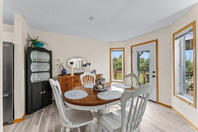 2001 Stonepine Ave, Hudson, WI 54016 - dining area with light wood finished floors, plenty of natural light, baseboards, and a textured ceiling