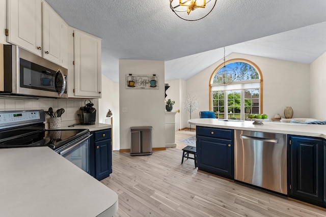 2001 Stonepine Ave, Hudson, WI 54016 - kitchen with stainless steel appliances, blue cabinets, light countertops, vaulted ceiling, and a textured ceiling