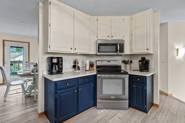2001 Stonepine Ave, Hudson, WI 54016 - kitchen with appliances with stainless steel finishes, blue cabinetry, light wood-type flooring, and a textured ceiling