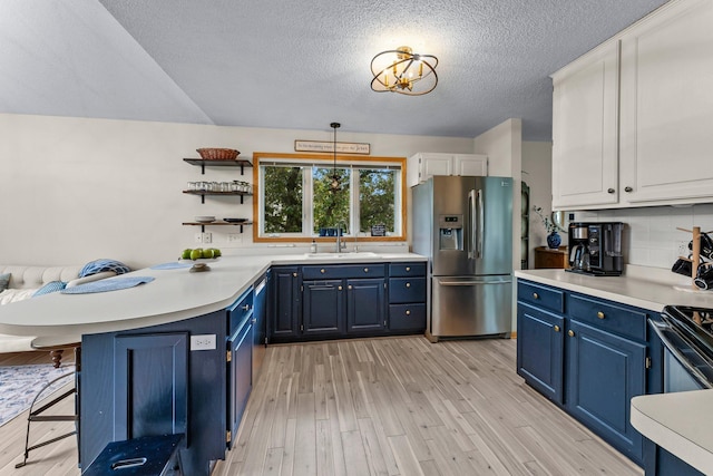 2001 Stonepine Ave, Hudson, WI 54016 - kitchen with stainless steel fridge, blue cabinetry, a sink, light wood-style floors, and light countertops