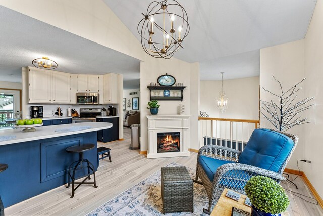 2001 Stonepine Ave, Hudson, WI 54016 - kitchen featuring stainless steel appliances, a chandelier, light countertops, a kitchen breakfast bar, and light wood finished floors