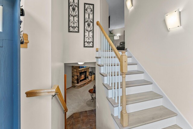 2001 Stonepine Ave, Hudson, WI 54016 - stairs with a fireplace, carpet floors, and stone finish floors