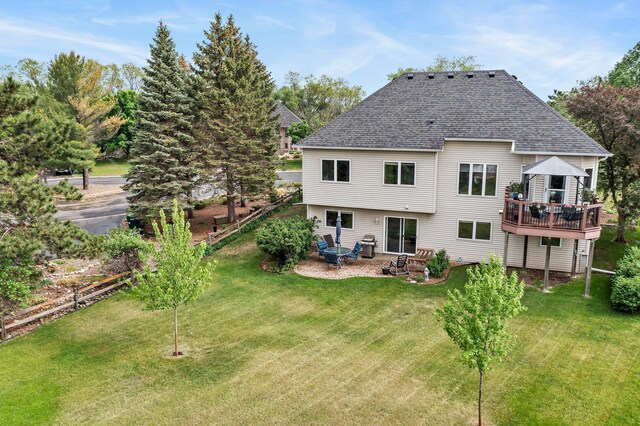 2001 Stonepine Ave, Hudson, WI 54016 - rear view of property featuring a yard, a shingled roof, a patio, and a wooden deck