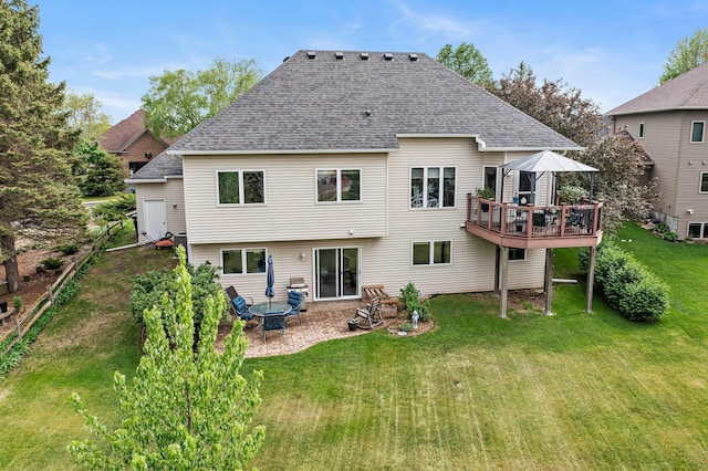 2001 Stonepine Ave, Hudson, WI 54016 - rear view of property featuring roof with shingles, a lawn, a wooden deck, a patio area, and a fire pit