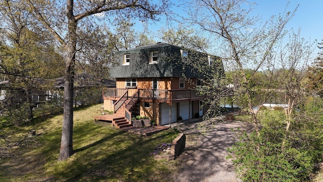 6032 Quinn Ave NW, Annandale, MN 55302 - view of front of home with a deck, asphalt driveway, a front lawn, stairway, and a gambrel roof