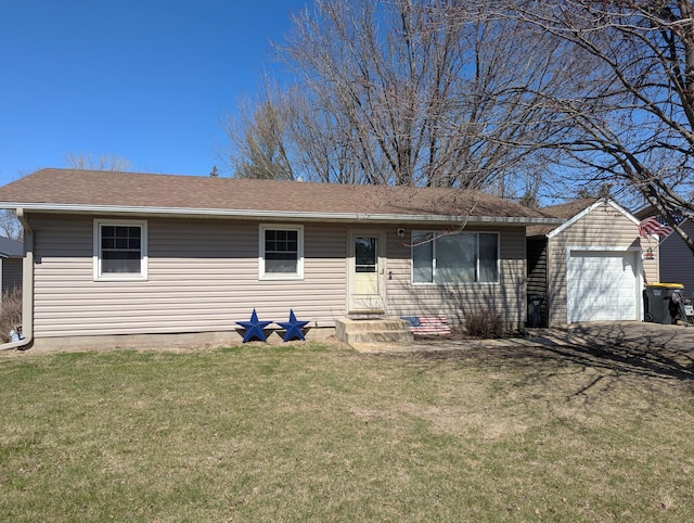 single story home with a garage, an outbuilding, a front lawn, driveway, and roof with shingles