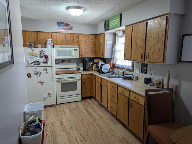 305 6th St SW, Kasson, MN 55944 - kitchen with white appliances, a sink, brown cabinets, light countertops, and light wood-style flooring