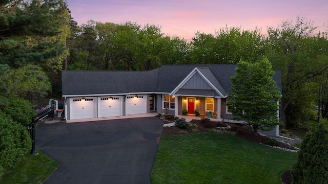 648 Sunset Ln, Mendota Heights, MN 55118 - single story home featuring covered porch, an attached garage, asphalt driveway, a yard, and board and batten siding