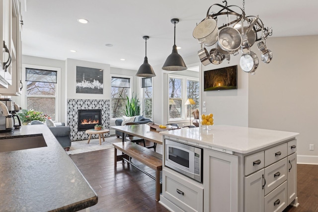 648 Sunset Ln, Mendota Heights, MN 55118 - kitchen with stainless steel microwave, plenty of natural light, a fireplace, dark wood-type flooring, and recessed lighting