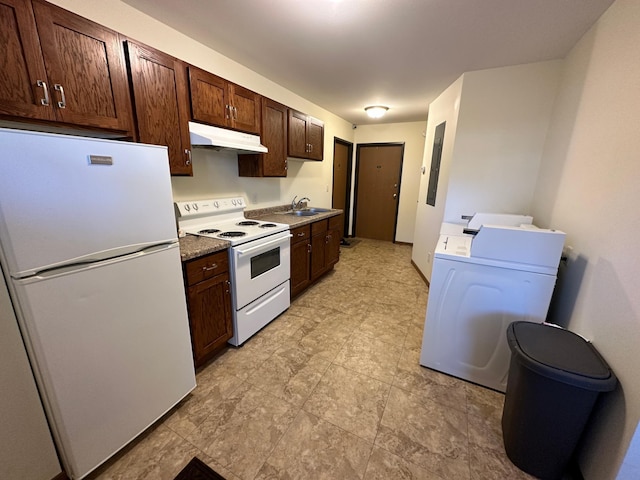 kitchen featuring white appliances, under cabinet range hood, a sink, dark brown cabinets, and separate washer and dryer