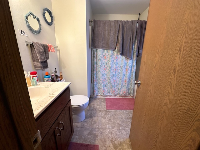 bathroom with vanity, toilet, and a shower