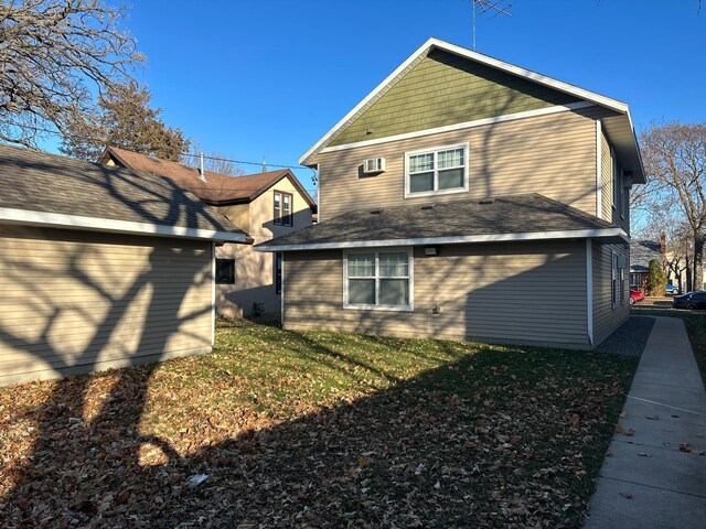 rear view of property with a lawn