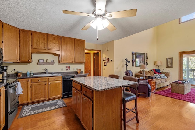 2200 15 1/2 St NW, Faribault, MN 55021 - kitchen with black dishwasher, stainless steel electric stove, a sink, wood finished floors, and a breakfast bar area