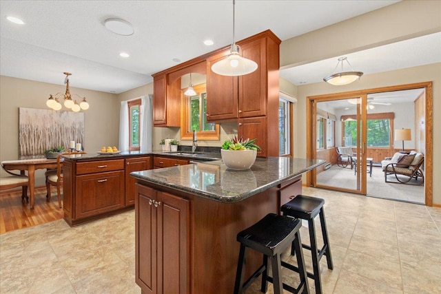 5935 County Road 11, Independence, MN 55359 - kitchen featuring a peninsula, pendant lighting, a sink, dark stone counters, and a breakfast bar area