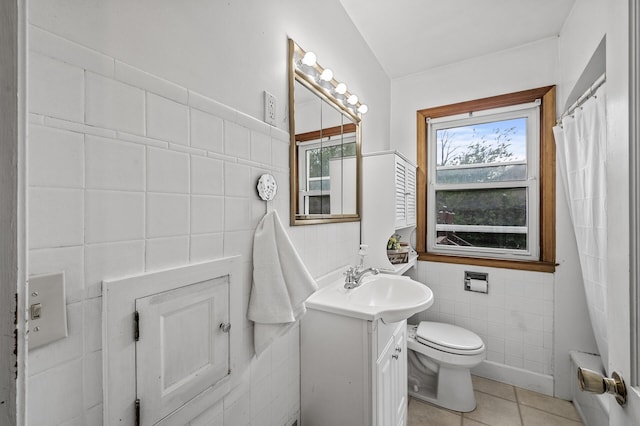 full bathroom with tile walls, toilet, vanity, and tile patterned flooring