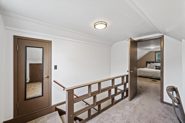 hallway featuring carpet flooring and lofted ceiling