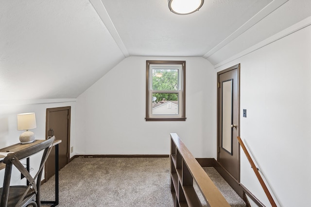 corridor with vaulted ceiling, carpet flooring, and baseboards