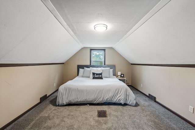 bedroom with carpet, vaulted ceiling, a textured ceiling, and baseboards