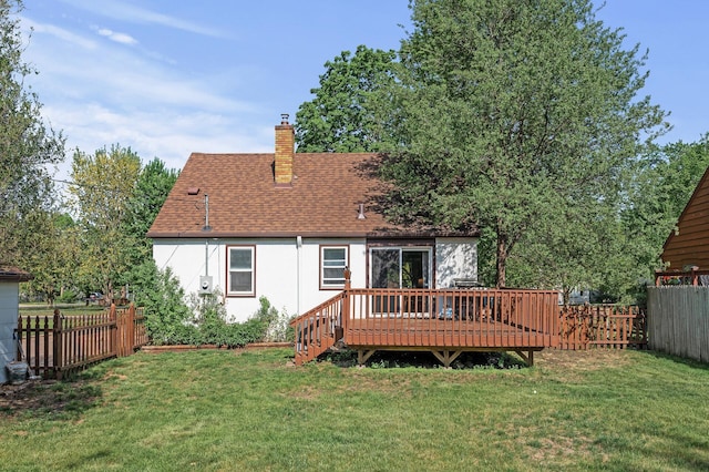 back of house with a wooden deck, a chimney, a shingled roof, and stucco siding