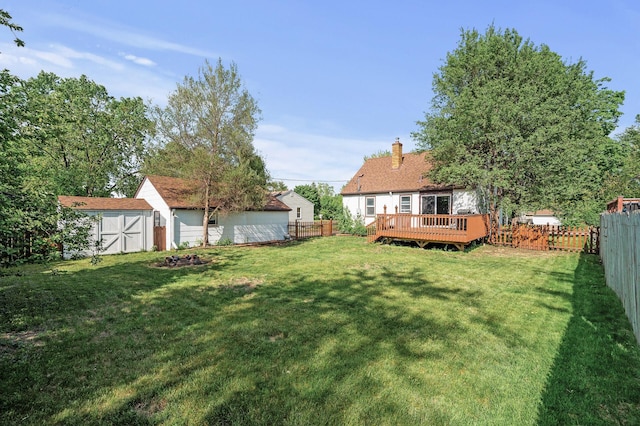 view of yard featuring a storage shed, a deck, and an outdoor structure
