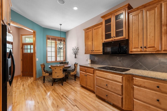 9363 Libby Ln, Eden Prairie, MN 55347 - kitchen featuring black appliances, brown cabinetry, light wood-style floors, decorative backsplash, and glass insert cabinets