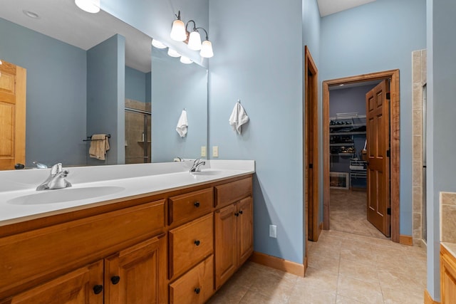 9363 Libby Ln, Eden Prairie, MN 55347 - full bathroom featuring a shower stall, double vanity, a spacious closet, tile patterned flooring, and baseboards