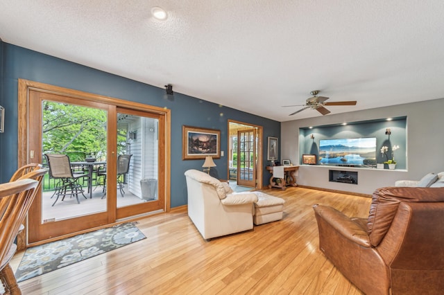 5155 Allen Dr, Woodbury, MN 55129 - living room featuring a textured ceiling, hardwood / wood-style floors, a ceiling fan, and baseboards