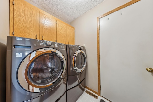 5155 Allen Dr, Woodbury, MN 55129 - washroom featuring washer and clothes dryer, cabinet space, a textured ceiling, and baseboards