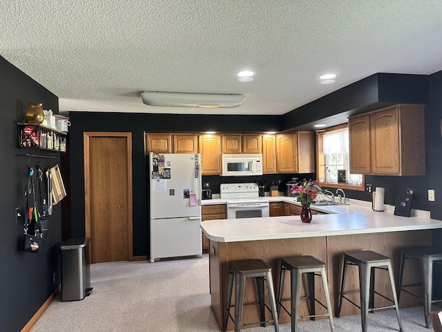 309 Oconnor St, Lakefield, MN 56150 - kitchen featuring white appliances, a textured ceiling, a sink, a peninsula, and light countertops