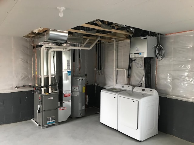 unfinished basement with washer and clothes dryer, water heater, and heating unit
