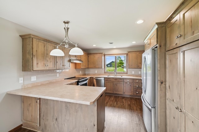 1516 Ranger Dr, Glencoe, MN 55336 - kitchen with appliances with stainless steel finishes, a peninsula, dark wood-style flooring, under cabinet range hood, and light countertops
