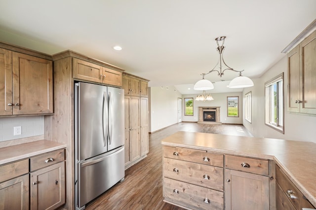 1516 Ranger Dr, Glencoe, MN 55336 - kitchen featuring freestanding refrigerator, dark wood finished floors, tasteful backsplash, light countertops, and hanging light fixtures