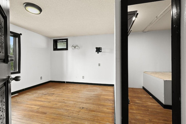19867 Twin Lakes Rd, Darling Twp, MN 56345 - empty room with light wood-style flooring, healthy amount of natural light, a textured ceiling, and baseboards