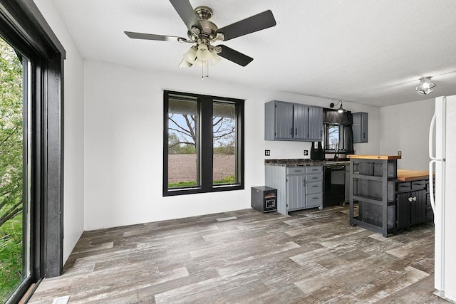 19867 Twin Lakes Rd, Darling Twp, MN 56345 - kitchen featuring wooden counters, dishwashing machine, wood finished floors, freestanding refrigerator, and a ceiling fan