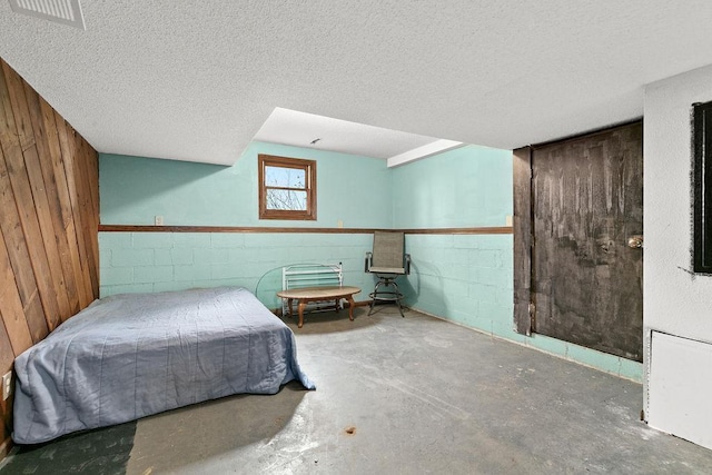 19867 Twin Lakes Rd, Darling Twp, MN 56345 - bedroom with unfinished concrete flooring, a textured ceiling, wood walls, and concrete block wall