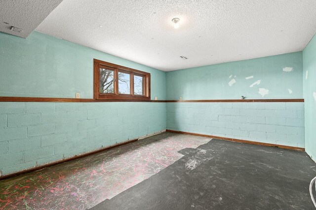 19867 Twin Lakes Rd, Darling Twp, MN 56345 - unfurnished room featuring a textured ceiling, concrete block wall, and baseboards