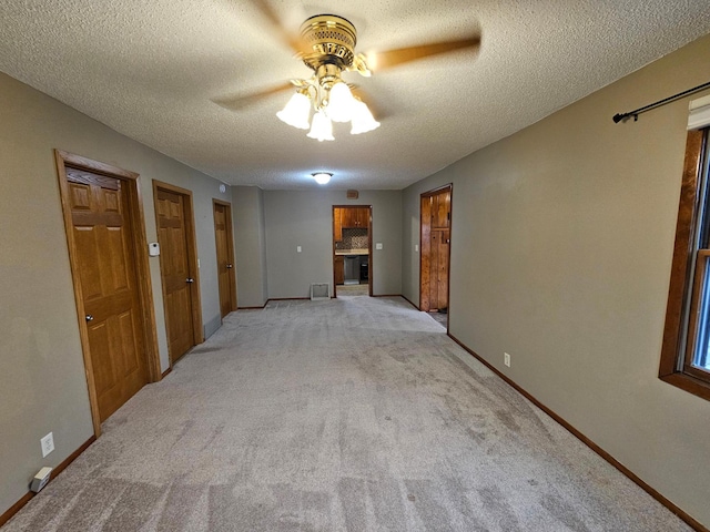 103 Bloomer St E, Morristown, MN 55052 - unfurnished living room featuring a ceiling fan, light carpet, a textured ceiling, and baseboards