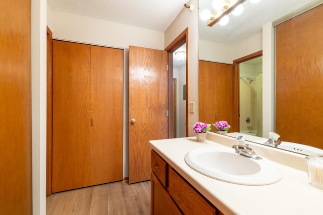 7625 Edinborough Way Unit 2116, Edina, MN 55435 - bathroom featuring vanity, wood finished floors, a shower, and a textured ceiling