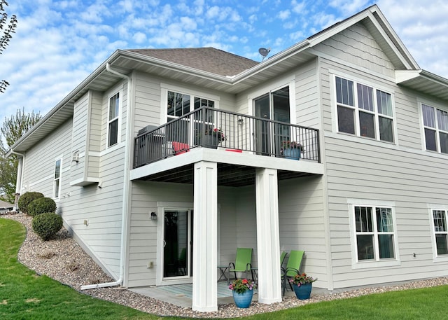 back of property with a balcony and a patio
